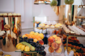 Fruit buffet for a wedding. Assortment of exotic fruits on the background of vineyards in the...