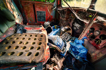 Interior of an abandoned old car. The neglected cabin of a heavy vehicle. Rubbish and cobwebs in the rusty interior of an old car.