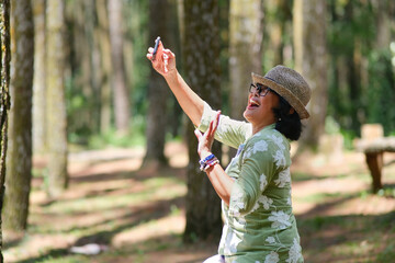 Side view: A woman wearing a hat is taking a selfie