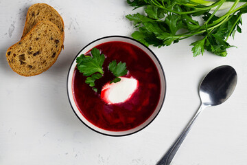 beetroot soup. red borscht with sour cream, green parsley, garlic on the white background. top view. Traditional Russian and Ukrainian dish.