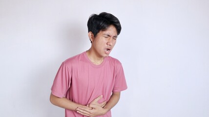 Asian man with a gesture holding his stomach because he has a stomach ache