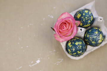 There are colored eggs for Easter in the egg tray. green eggs with yellow spots and white dots and lines