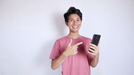 excited asian man with gesture holding and pointing at smartphone