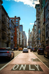 New York City vintage-style photo of street landscape with high rising buildings and cars in Soho,...