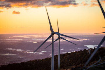 Turning wind power plant during sunrise on a mountain in Austria