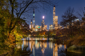Fototapeta na wymiar Billionaires' Row skyscrapers and reflection on Central Park Lake at night. Manhattan, New York City