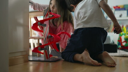 Children playing in bedroom. Siblings Playing with Toy Parking Lot Structure, Brother and Sister...
