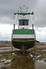 un bateau de pêche vert sur la plage