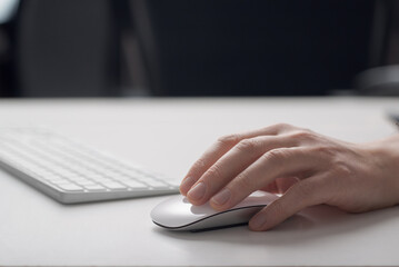 A man works at a computer. Computer mouse close-up.