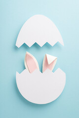Delightful Easter surprise concept. Overhead vertical shot of amusing bunny ears emerging from a...