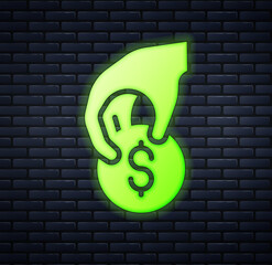 Glowing neon Hand holding casino chips icon isolated on brick wall background. Casino gambling. Vector