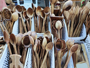 Wooden brown kitchen spoons for mixing food, on the shop window