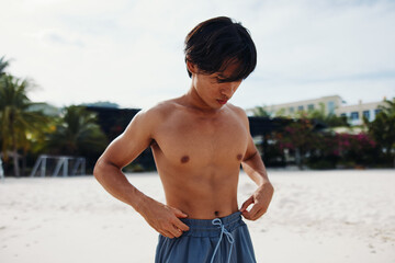 Fototapeta na wymiar Muscular Asian Athlete Running on Beach, Exuding Energy and Freedom in Fitness Lifestyle