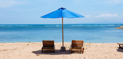 Banner relaxing on the beach. Sunbeds and umbrella against the background of the blue ocean.
