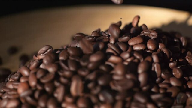 Beautiful time-lapse footage of falling coffee beans 4K. Slow motion of roasted coffee beans falling. Organic coffee seeds.