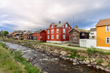 Fototapeta na wymiar A picturesque view of Roros showcases historical buildings alongside the flowing Glomma River, reflecting Norway's rich cultural heritage