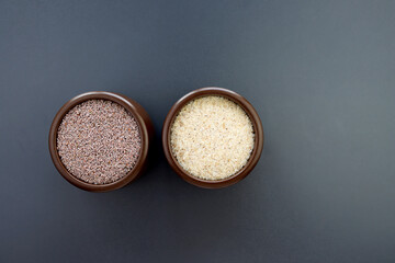 Psyllium seeds and husks in round brown bowls on a gray background.