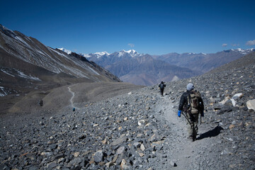 Trekkers on trail with mountains at background Image.