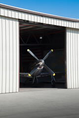 Four-blade Propeller of High-Performance Aircraft Appears Between Hangar Doors