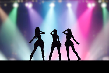 ステージ上の3人の女性アイドルとカラフルなスポットライト