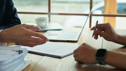 Unrecognizable male insurance agent in suit pointing at contract document to client put a signature