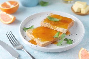 Sandwiches with marmalade, orange juice and coffee ready for breakfast