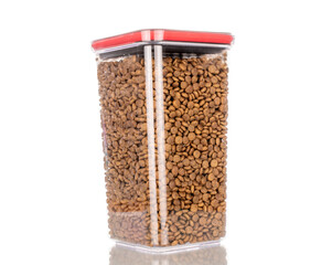 Dry dog food in plastic container, macro, isolated on white background.