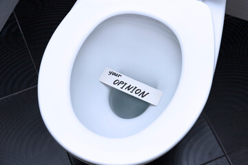 The words, the phrase, YOUR OPINION is written on the note card and floats in the toilet bowl as a reminder of the importance of customer feedback.