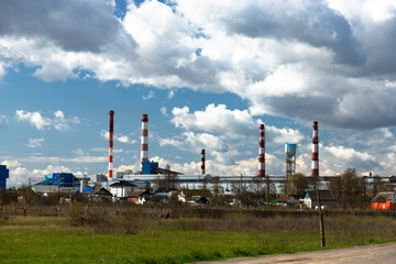 Fototapeta na wymiar Industrial landscape of a glass factory with pipes, reservoir chimneys.
