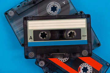 Retro audio cassette tape from the 80s on a blue background.