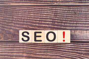 Word SEO is written on wooden blocks on a wooden background.