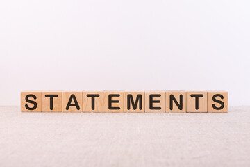 STATEMENTS word concept written on wooden cubes lying on a light table and light background.