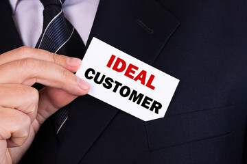 Businessman putting a card with text ideal customer in the pocket