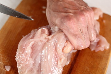 Slicing chicken breast. Making Chicken, Cheese and Leek Parcel Series.