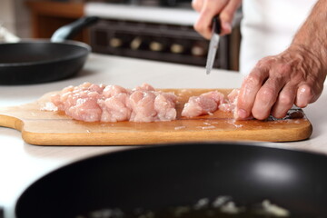 Slicing chicken breast. Making Chicken, Cheese and Leek Parcel Series.