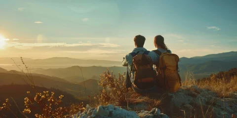 Fotobehang young couple of travelers looking at the sunset in the mountains Generative AI © València