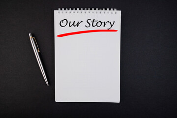 Our Story text, inscription, phrase is written in a notebook that lies on a dark table and a pen. Business concept.