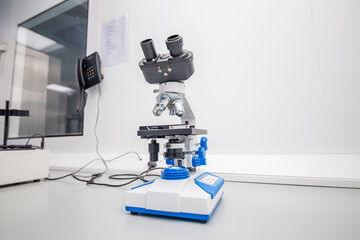 An isolated Compound Microscope in a science laboratory for research analysis and control study trials for studying chemistry medical experiment discovery magnification of microbiology microorganisms 