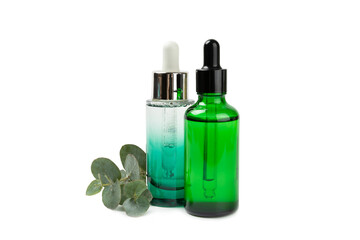 Eucalyptus essential oil in a glass bottle with green eucalyptus leaves isolated on white background. Aromatherapy. Spa. Concept of natural cosmetology and beauty industry.