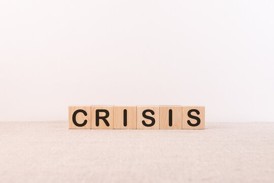 Word CRISIS is made of wooden building blocks on a light background.