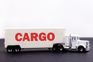 Cargo word concept written on board a lorry trailer on a dark table and light background