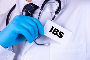 Doctor holding a card with text IBS medical concept