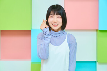 ハートの形を作る若い女性とカラフルな背景