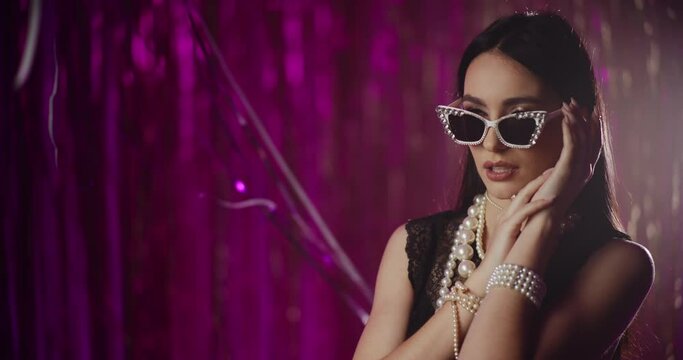 Sensual woman in pearl jewelry and sunglasses