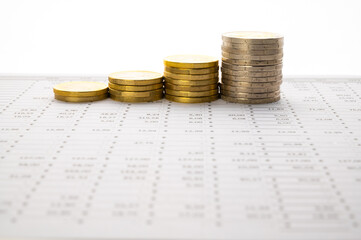 Table with calculations, budget, and stacks of coins; increase or decrease in money or budget.
