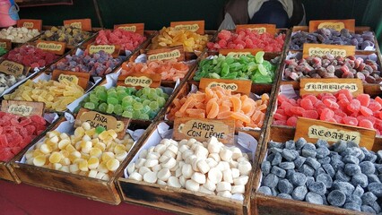 Wooden boxes with colorful sweets and gummies at a street stall at a fair