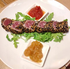Red tuna tataki with sesame seed accompanied by arugula,caramelized onion and spicy tomato sauce