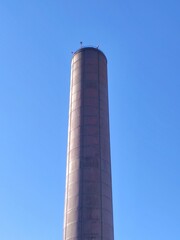 Industrial steel chimney on a sunny blue sky day