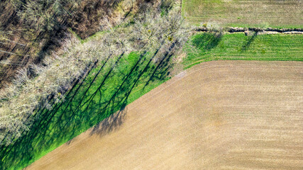 This image captures a top-down aerial view of farmland, showcasing the striking contrast between...