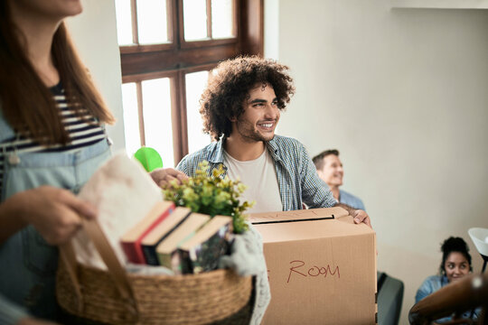 Group of people moving house with boxes and plants
